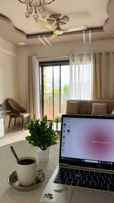 A wooden desk placed directly in front of a large window with sunlight streaming onto a laptop